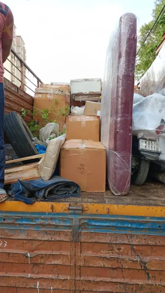 Professional Packers and Movers in Koramangala Bangalore loading household goods and furniture in covered transport truck